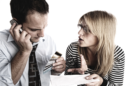 Couple with bill, credit cards and phone