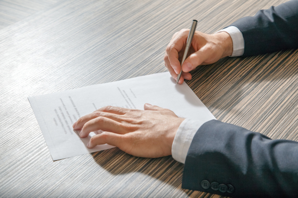 A man filling out paperwork for a bank account.