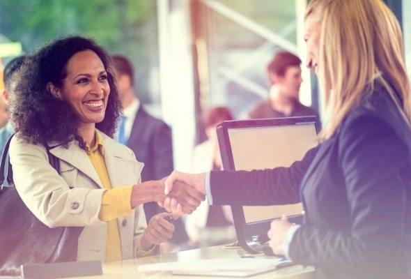 A woman shaking hands with a bank teller.