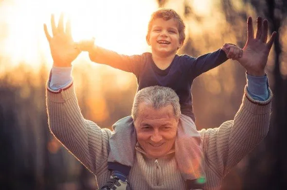 A grandparent carrying their grandchild.