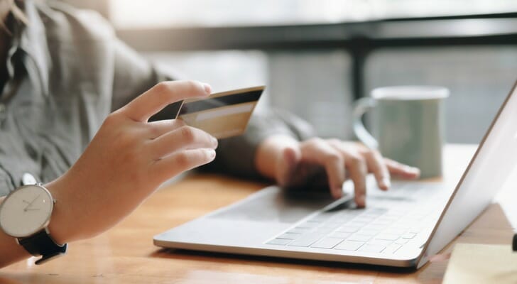 Man uses his credit card to make an online purchase.