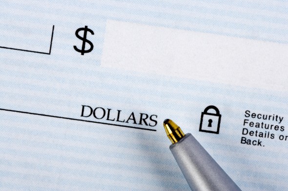 The tip of a pen resting beneath the box on the right side of a check where you write in the amount.