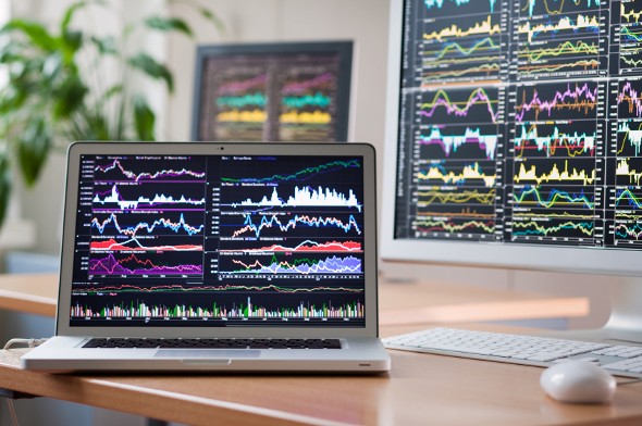 Computer screens showing trading charts.