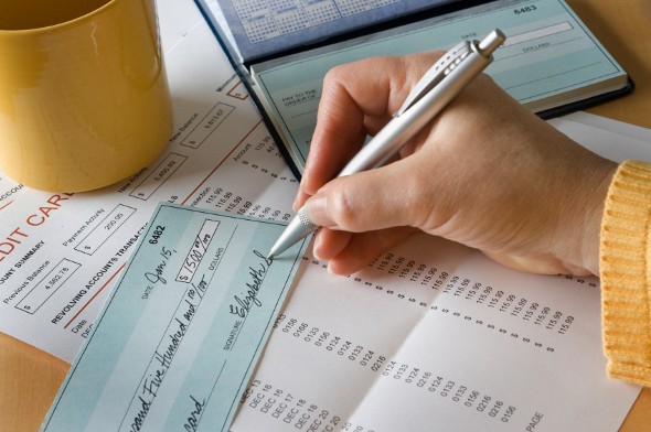 A woman writing a check for her new checking account.