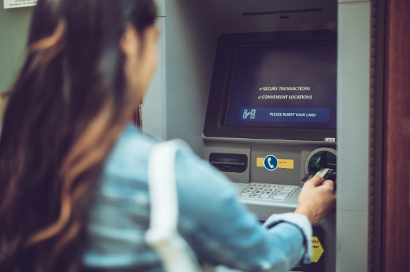 Closeup of a woman using an ATM.