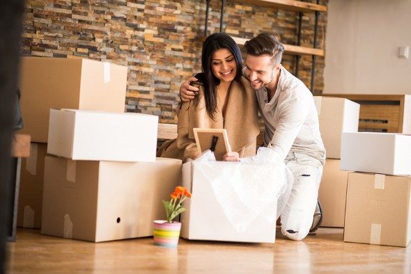 A husband and wife unpacking boxes in their new home.