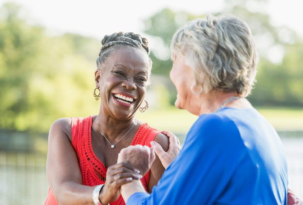 Two women talking and laughing, enjoying their retirement.