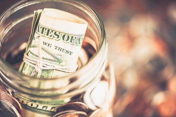 A glass jar with cash and coins.
