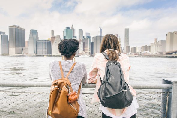Two college students chat between classes, discussing college tuition tax deductions.