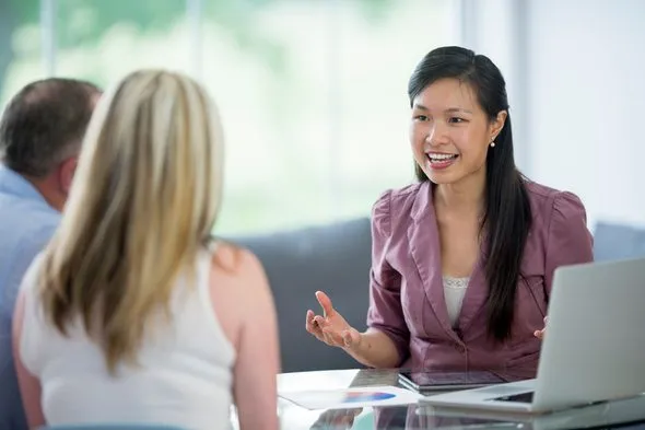 A couple sitting down to open a bank account.