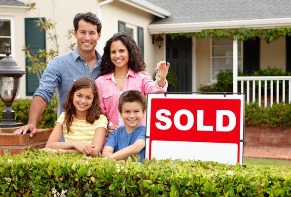 A family in front of their newly purchased home, where their property taxes are included in the mortgage.