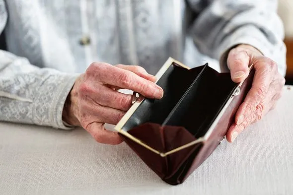 Elderly woman opening an empty purse.