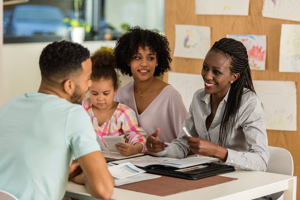 A family sits down with their Certified Financial Planner™ (CFP®).