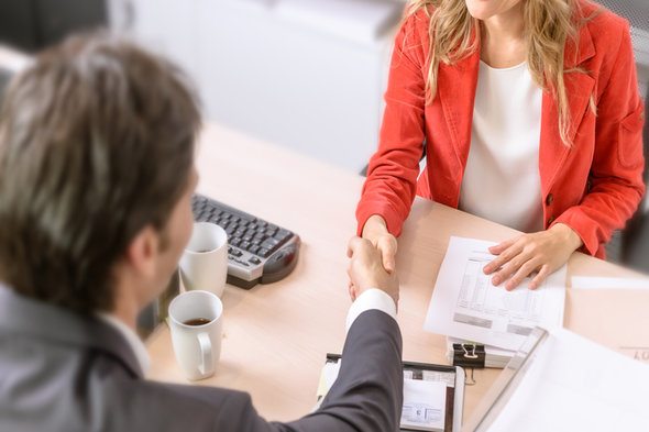 A woman visits a bank to ask what she needs to open a bank account.