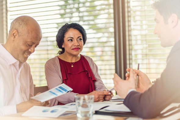 A couple discussing their joint account with a financial advisor.