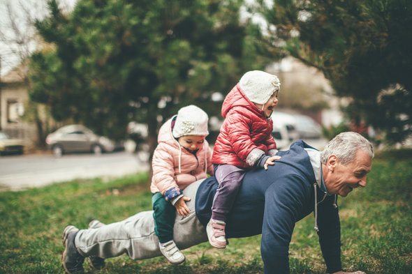 A grandfather enjoying retirement with his grandchildren, having planned to retire at 55.