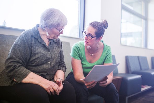 A woman and healthcare worker reviewing healthcare options for her plan to retire at 55.