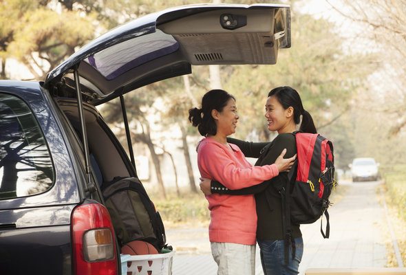 A mother hugging her daughter before she goes off to college.