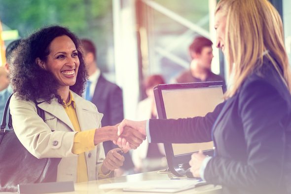 Two women in the financial services industry shake hands.