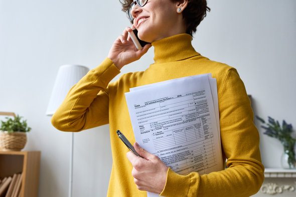 A woman consulting a tax expert about a tax form.
