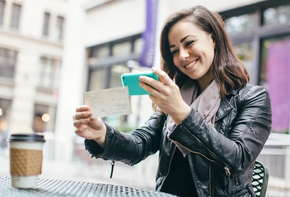 A woman depositing a check into her bank account through a mobile app.