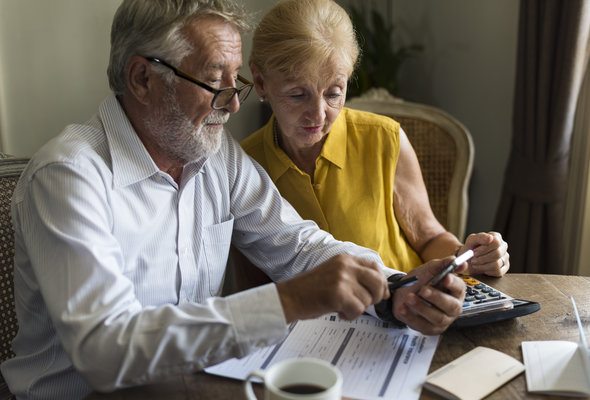 A senior couple reviewing their bank statement.