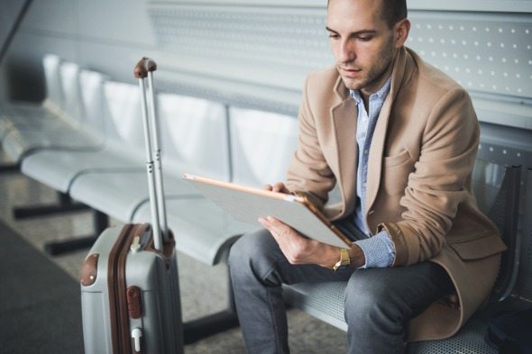 A traveler looking up where to exchange foreign currency on a tablet.