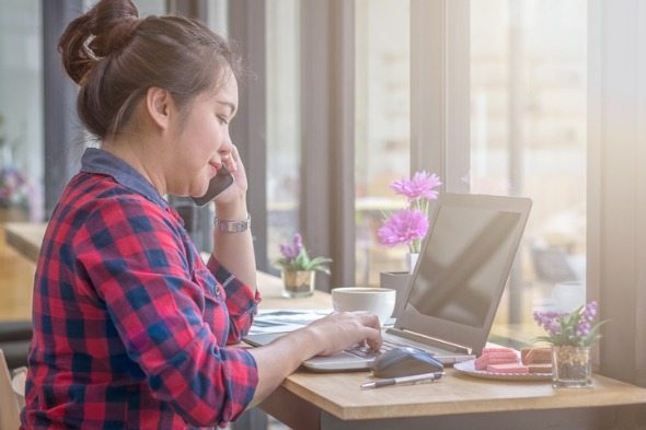 A woman on the phone with her bank, reporting a lost debit card.