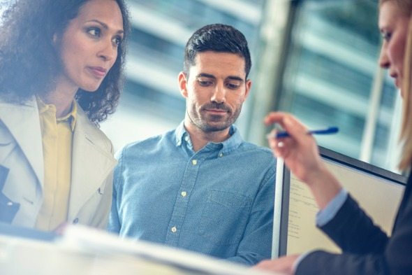 A couple sit down with an agent at their bank to report a lost debit card.