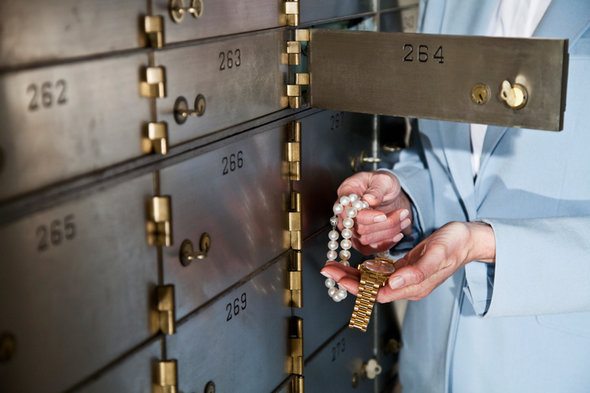 A woman looking at jewelry stored in a safety deposit box.
