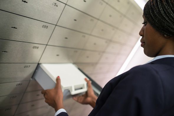 A bank manager withdrawing a safety deposit box.