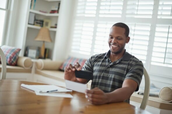 A man cashing a check with a mobile bank application.