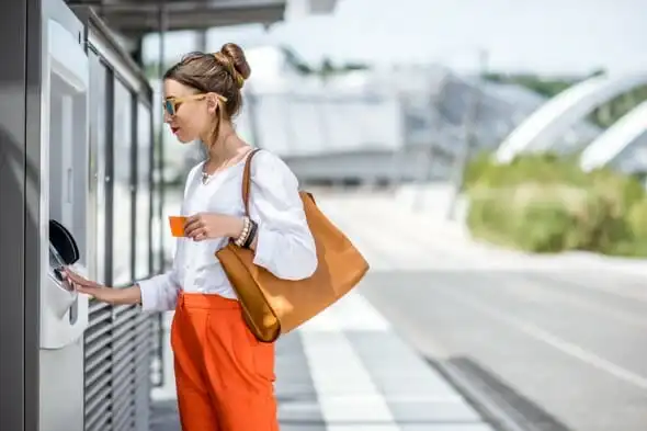 A woman withdrawing cash from an ATM.