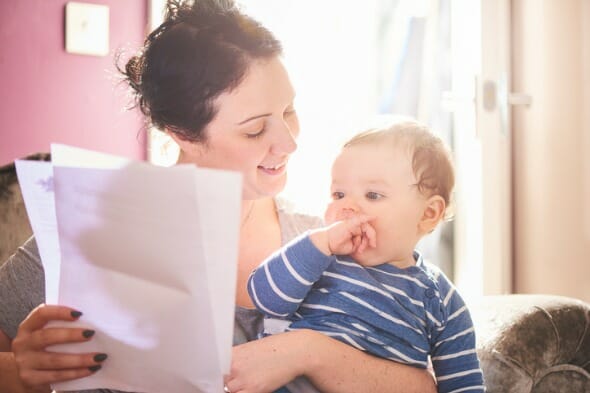 A mother holding up documents for an estate plan in front of her child.