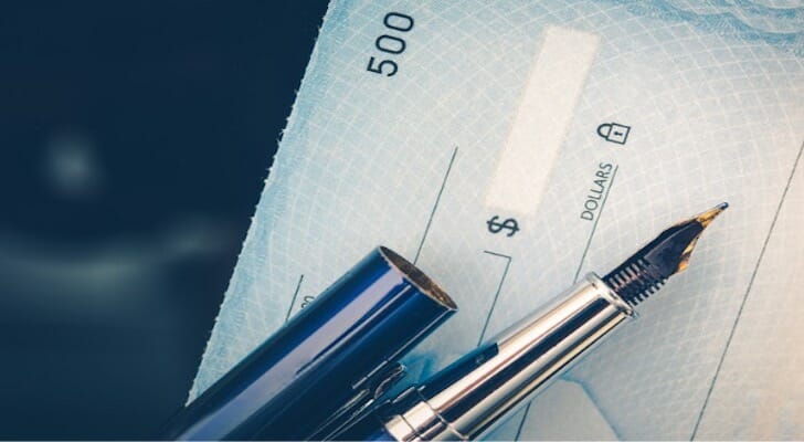 Closeup of a blank personal check and a pen.