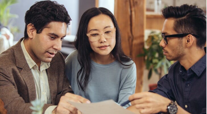 An investment broker discusses his clients' portfolio with them.