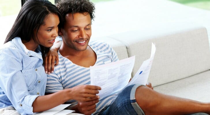 A couple reading a bank statement.