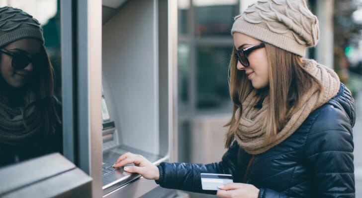 A woman using an ATM machine.