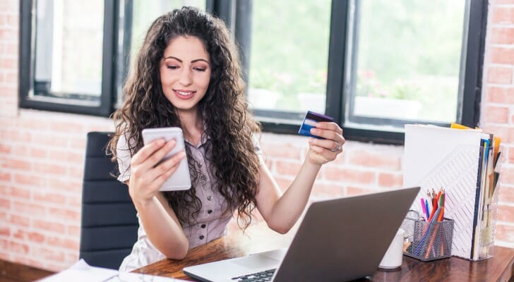 A woman comparing US Bank vs. Wells Fargo bank fees.