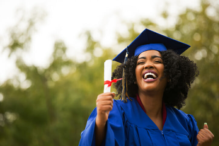 A college graduate holds her diploma.