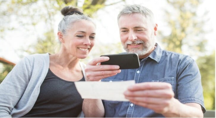 A couple depositing a check via an online account app.