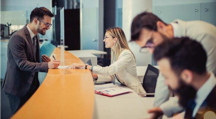 A client speaking with a bank teller.