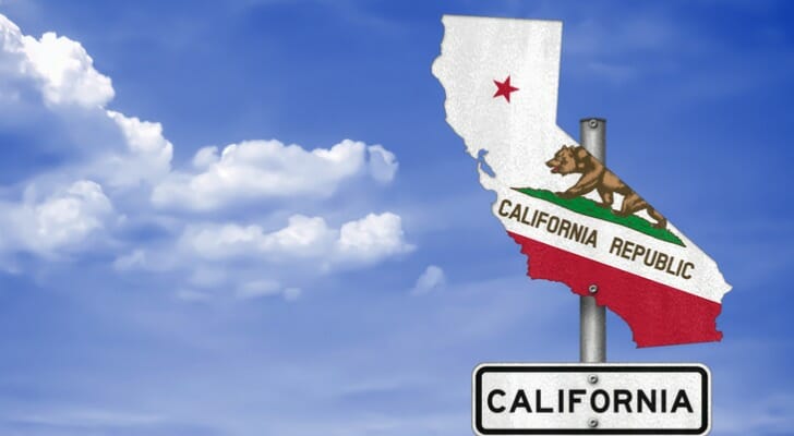 A road sign in the shape of the state of California, painted with the state's flag.