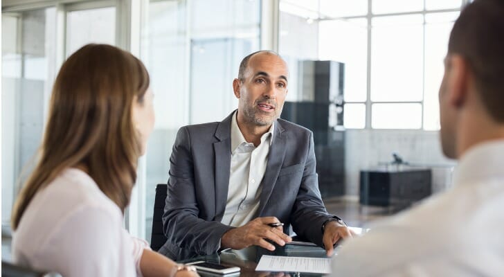A couple ask their advisor how to close a bank account.