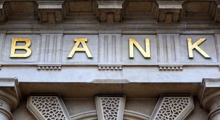 Closeup of the word "Bank" on the portico of a branch.
