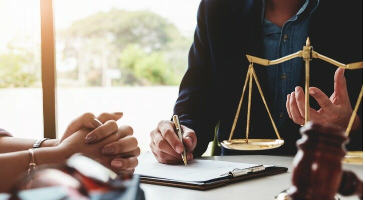 A woman discusses Illinois divorce laws with her attorney.