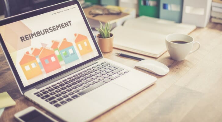 A laptop open to a page that reads "reimbursement."