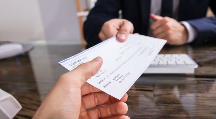 A client receiving a bank check from a manager at a branch.