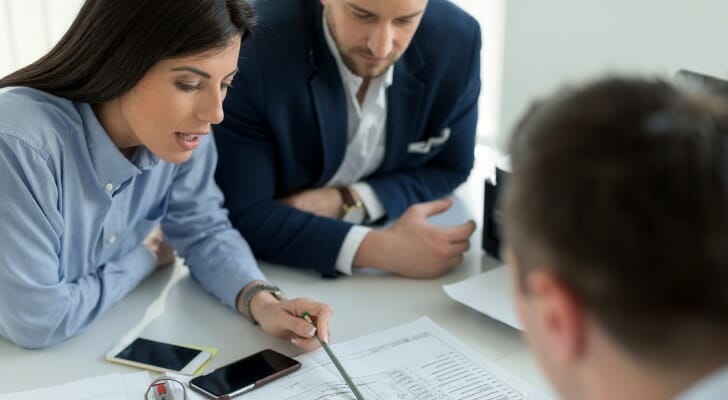 A couple locating their bank transit number for financial documents.