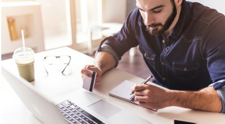 A man writing down his bank transit number.